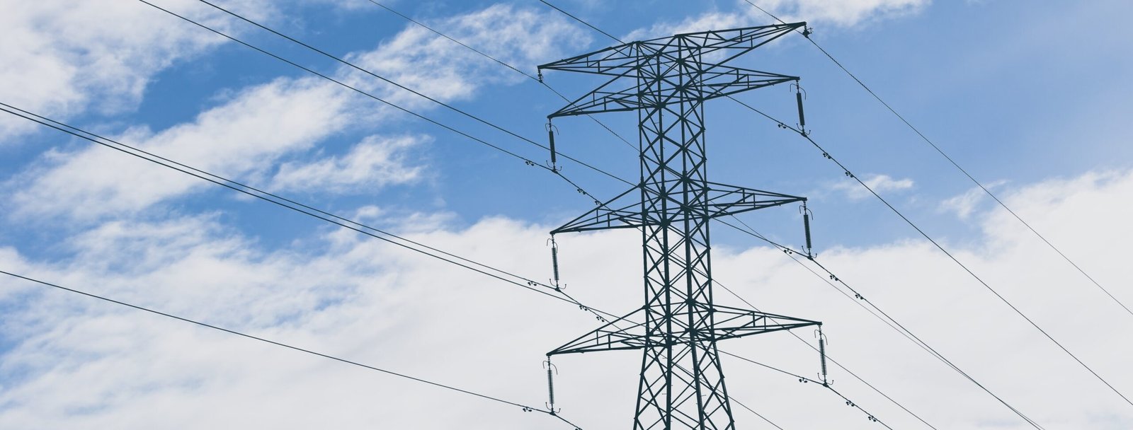 Electric tow4er with a blue cloudy sky in the background